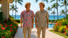 Two men walking along wearing Hawaiian shirts with palm trees and ocean in the background
